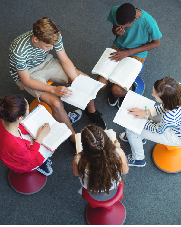five people sitting in a circle studying